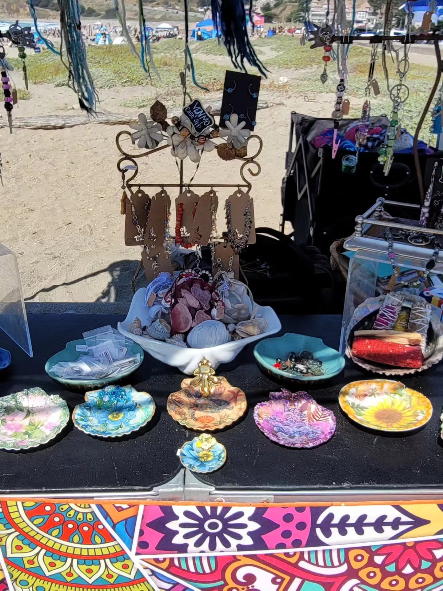 Dana's beach stall: painted shells, hangers, and jewelry on the sand